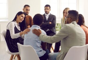 Group of diverse professionals supporting a colleague during a workplace well-being session